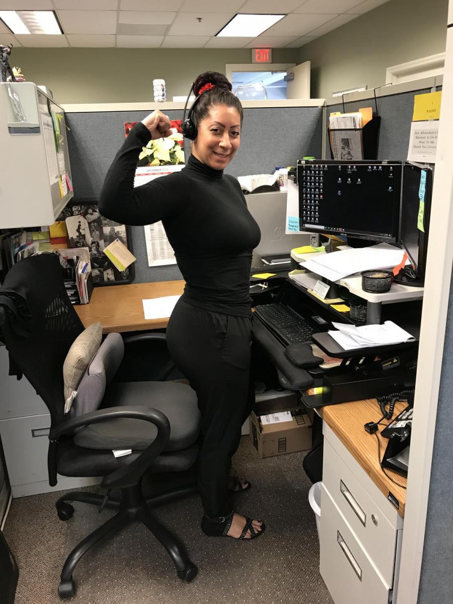 Image of Elizabeth Otero standing up at her desk.