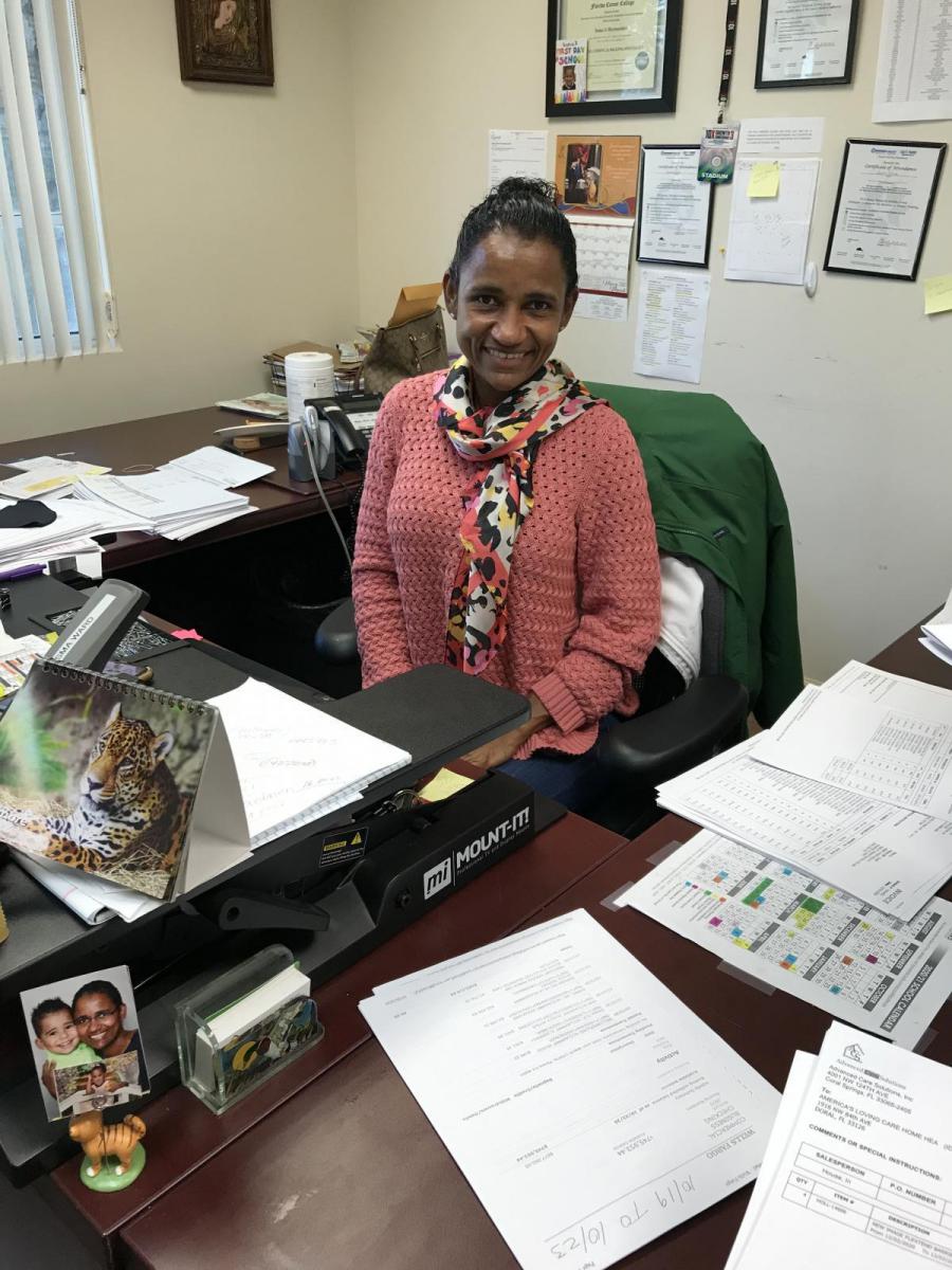 Image of Isma Ward sitting at her desk.