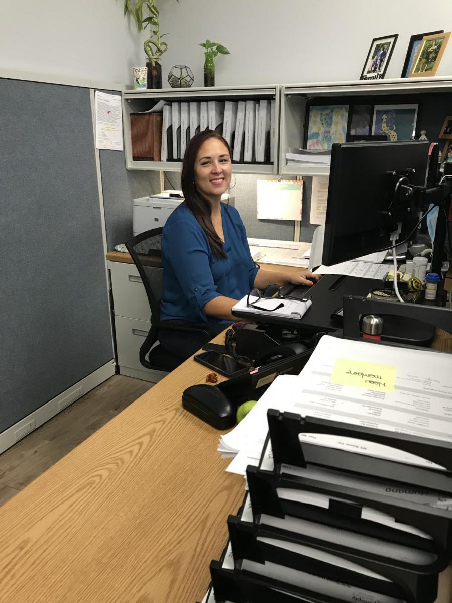Image of Paula Alvarez sitting at a desk in the office.